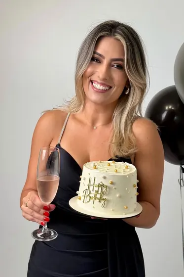 Aniversariante com taça e bolo de 40 anos
