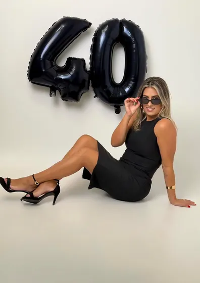 Ensaio de 40 anos com balões pretos e óculos escuros