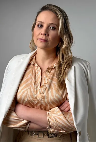 Profissional de blazer branco com braços cruzados
