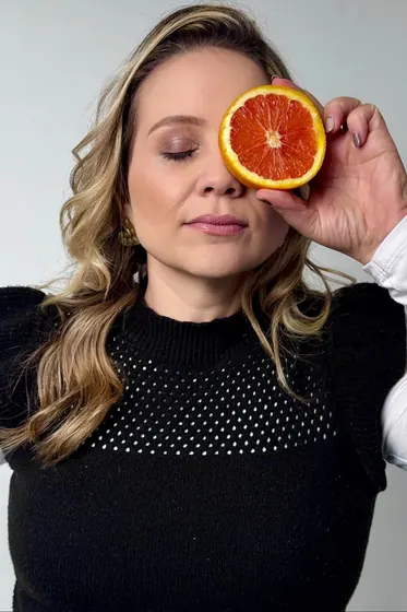 Nutricionista com fatia de laranja sobre o olho