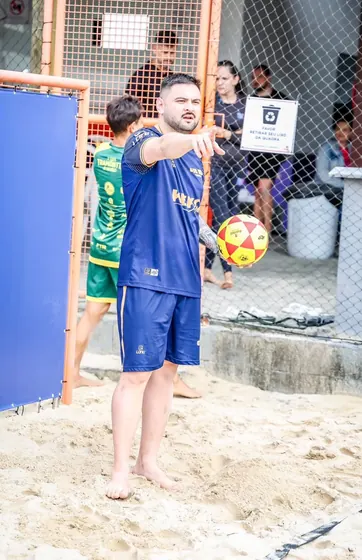 Jogador de beach soccer apontando em quadra