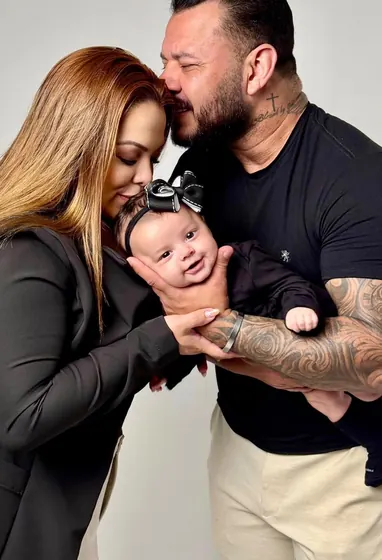 Casal segurando bebê recém-nascida no colo